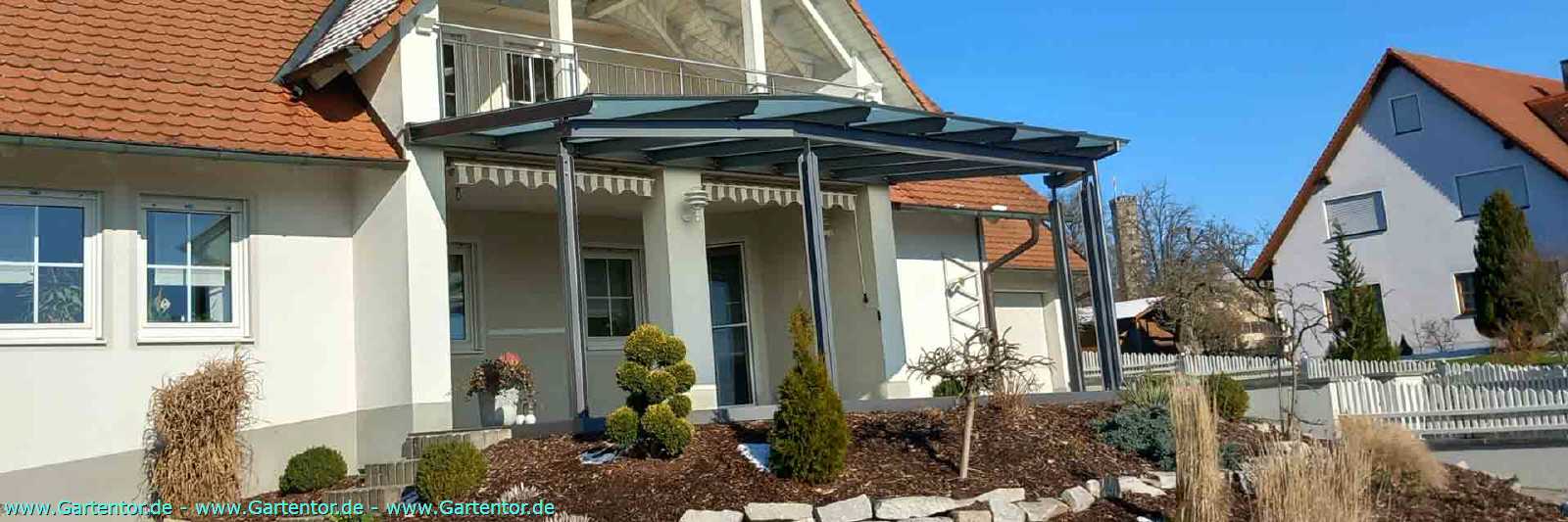 Hochwertige Terrassen&uuml;berdachung aus pulverbeschichtetem Metall mit gro&szlig;fl&auml;chigem Glasdach und moderner Architektur.